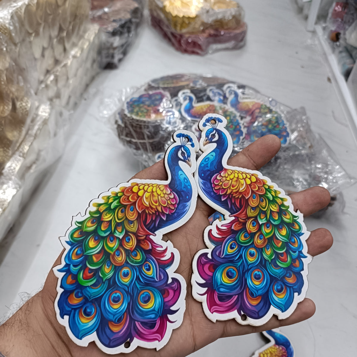 6-inch peacock MDF cutout set with colorful feather designs, held in hand
