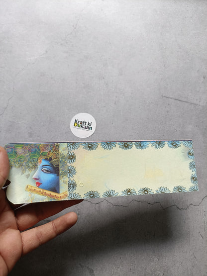 Single rakhi card with cream background, floral border and blue face portrait, held