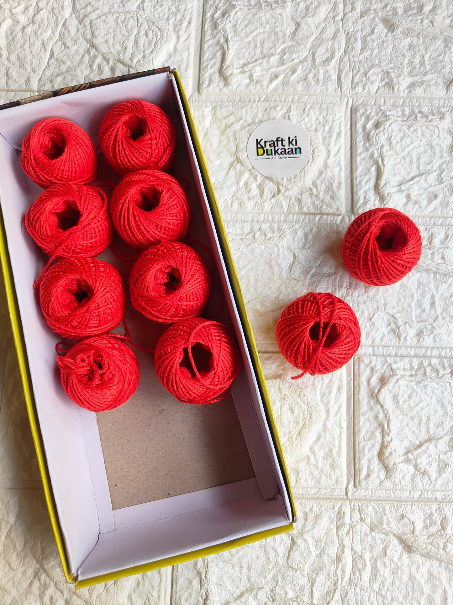 Rakhi thread spool set in red, open box with multiple thread balls and spare spool