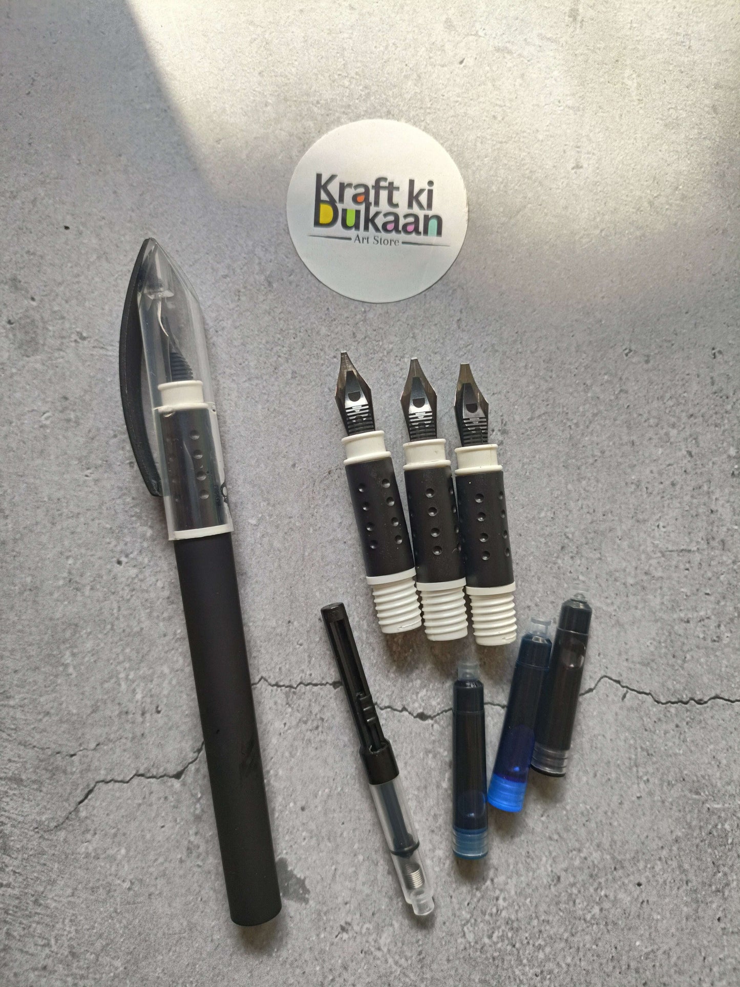 Calligraphy pen 8-piece set with black pens and metal nibs, laid out