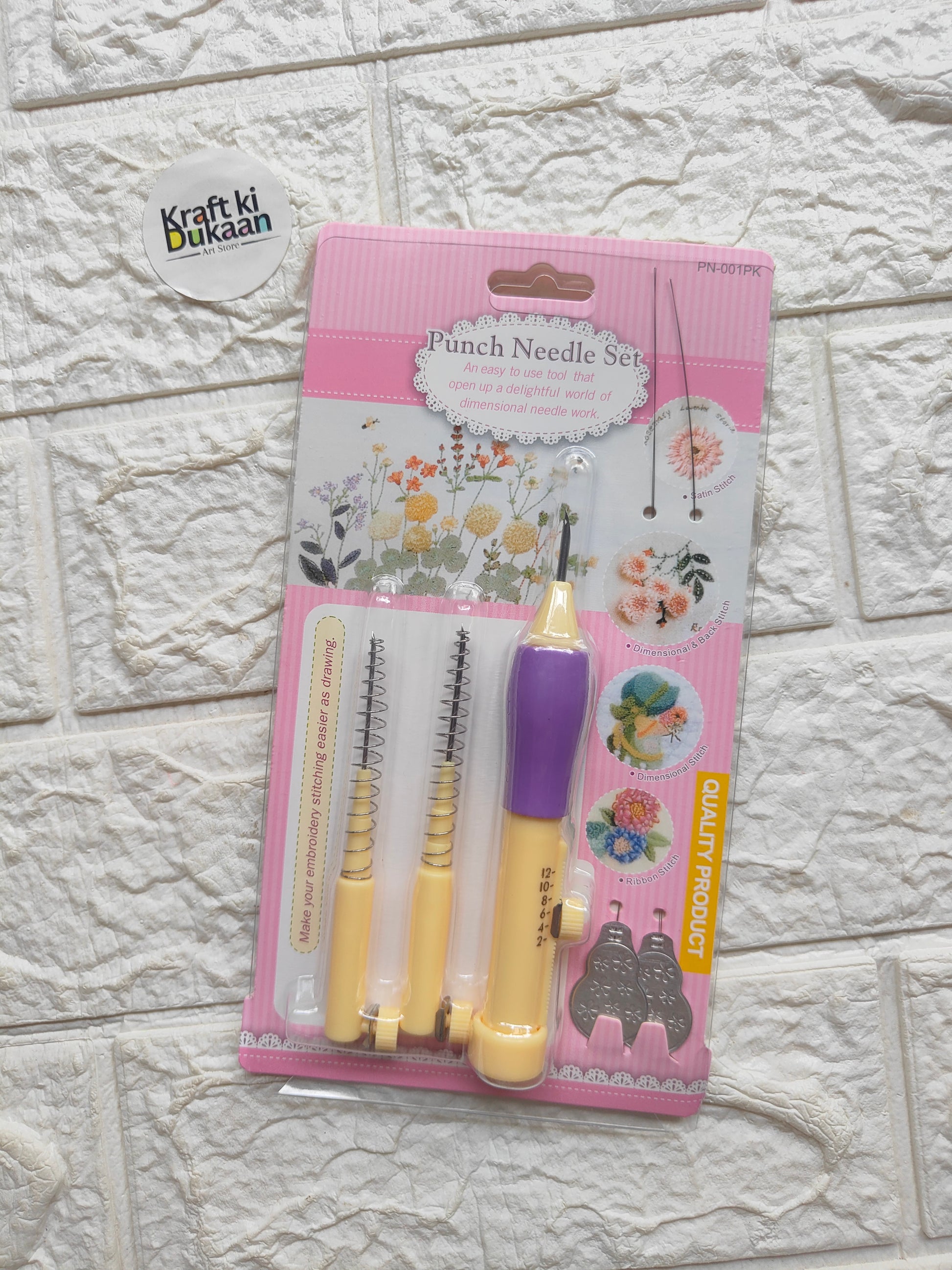 Packaged punch needle set blister with purple handle and two beige needle tools