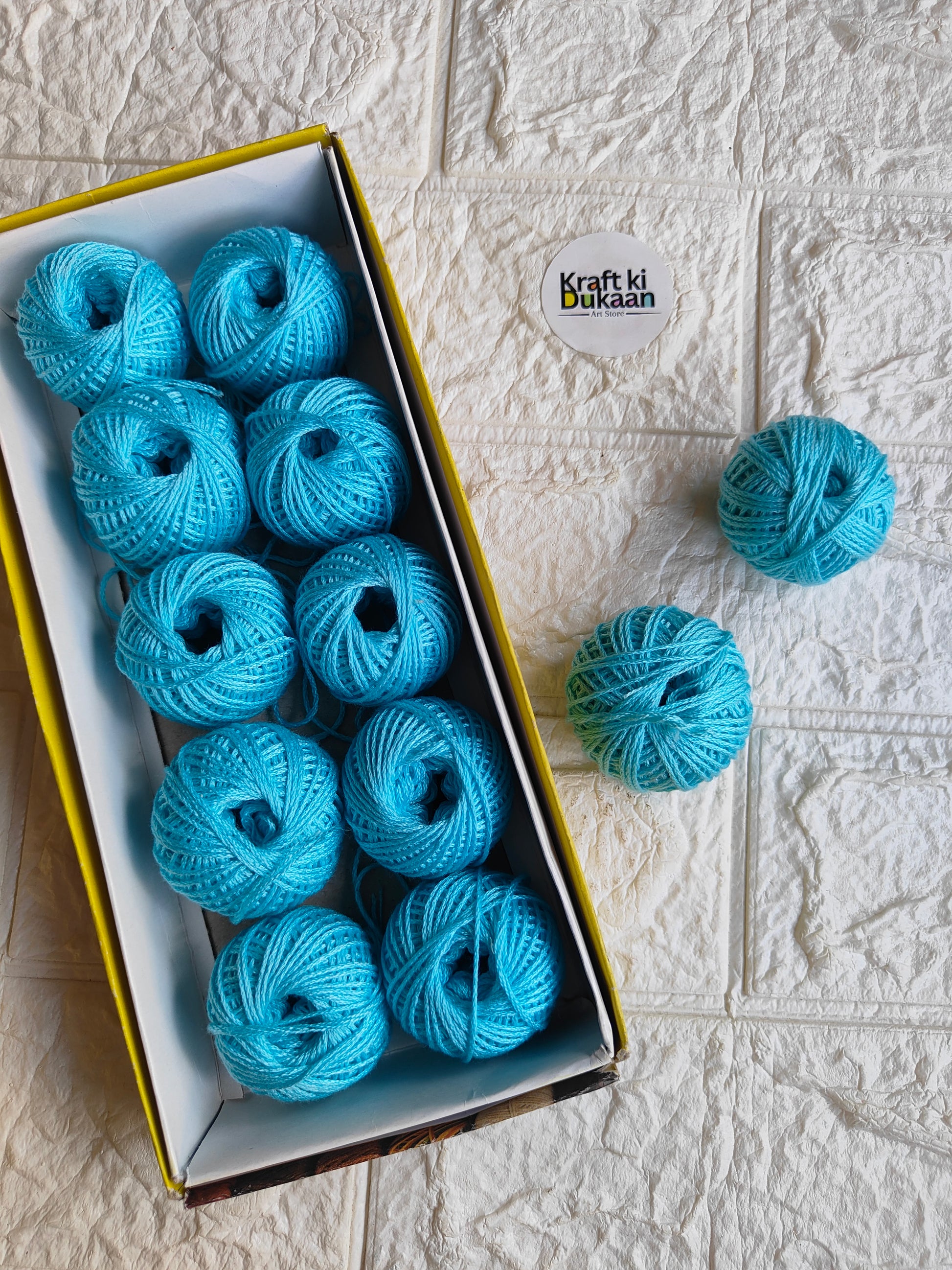 Rakhi thread spool set in turquoise blue, open box with several thread spools