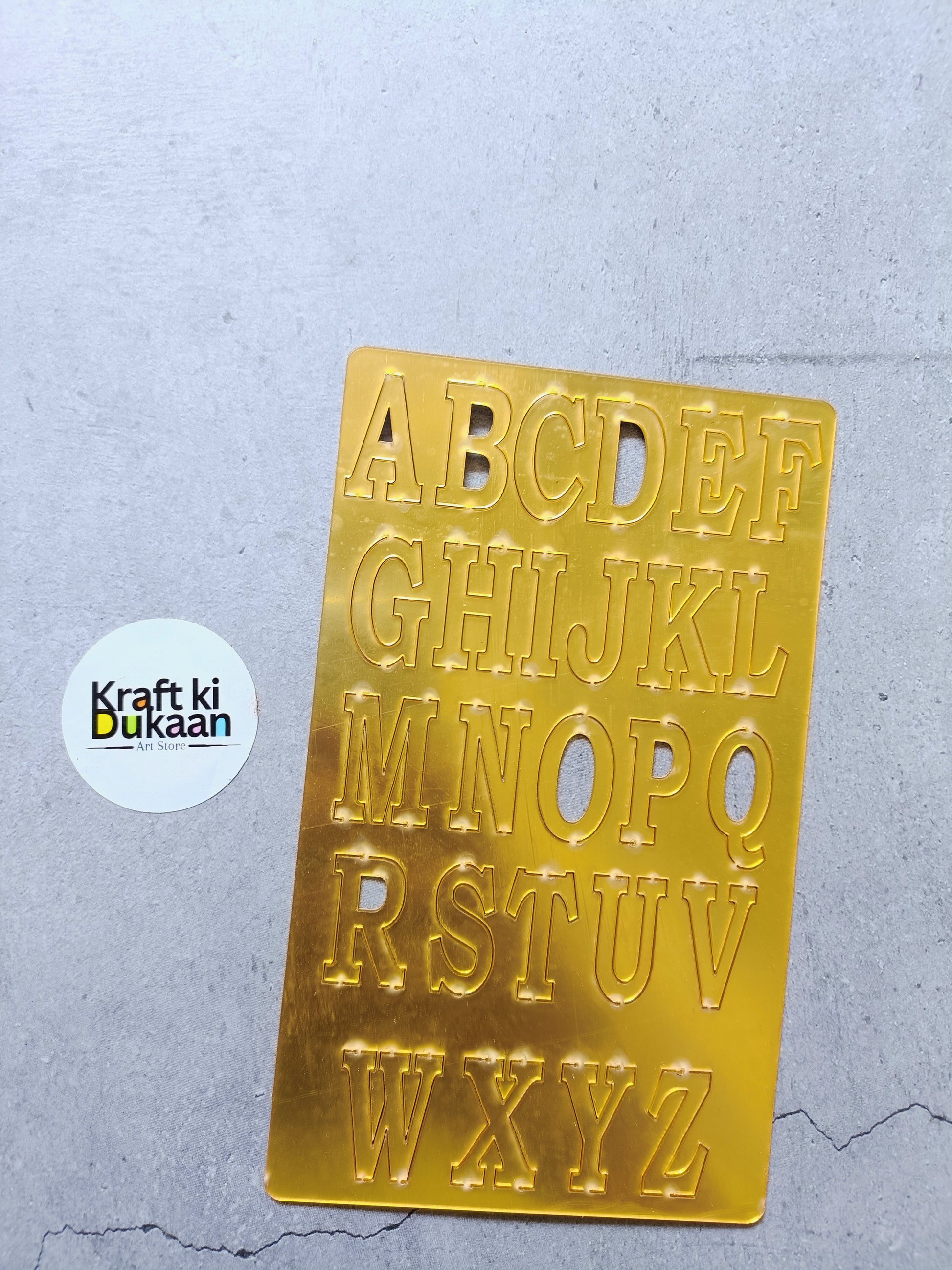 Acrylic alphabet set with gold-tone cutout letters A–Z on a clear plaque
