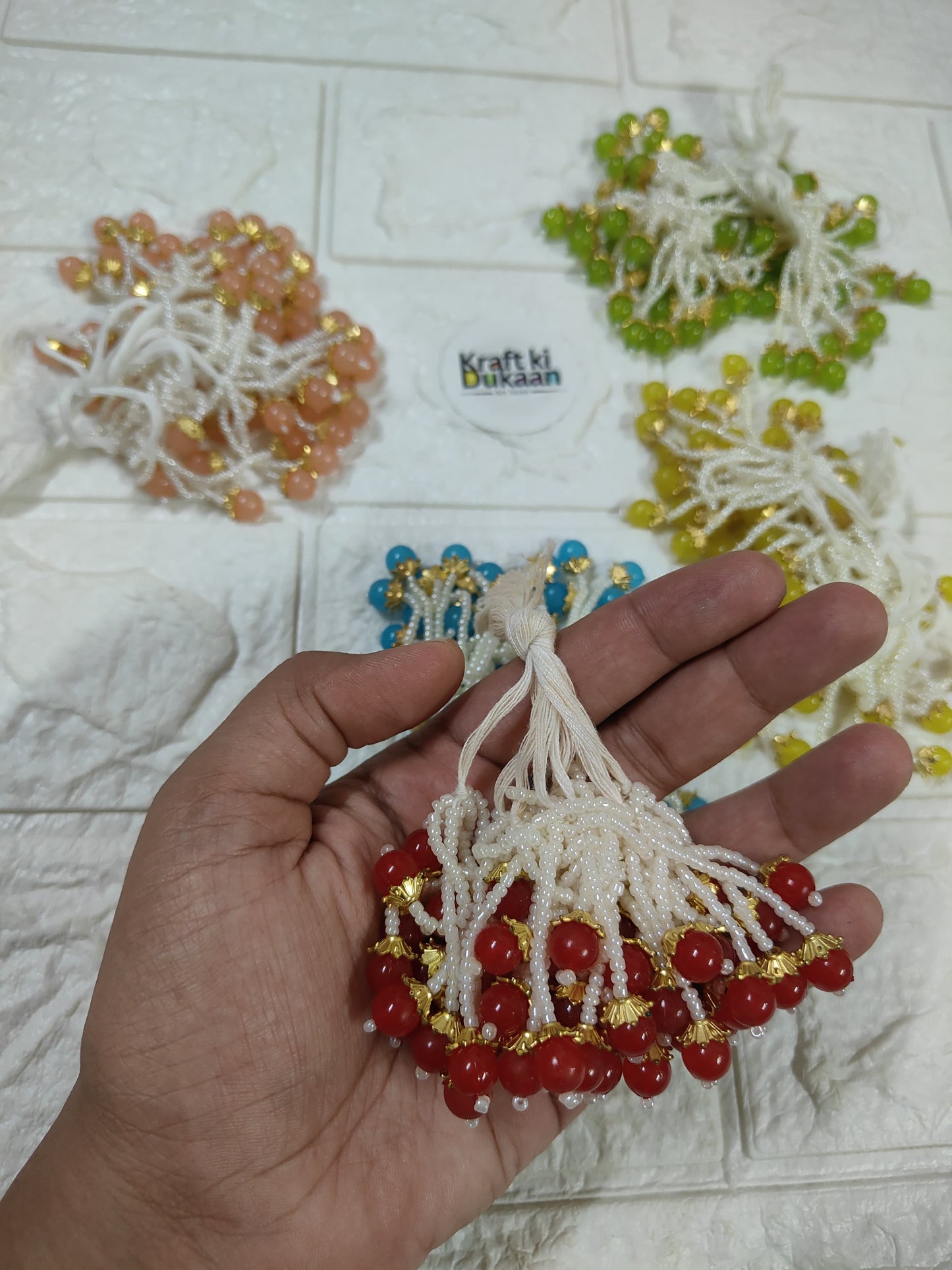 Beaded tassel with white fringe, red beads and gold accents