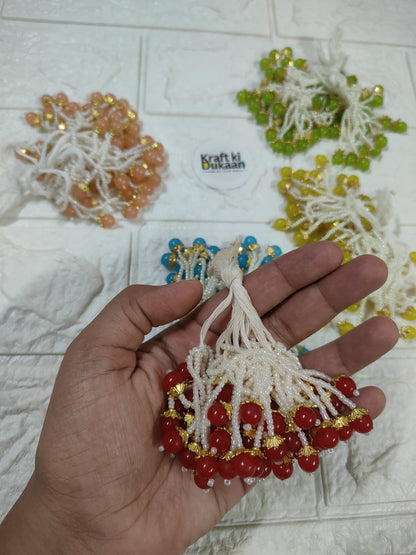 Beaded tassel with white fringe, red beads and gold accents