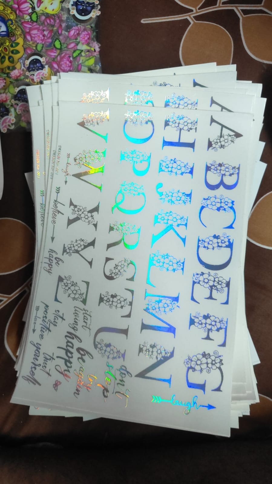 Holographic sticker sheet with mixed bow and star letter designs on white backing