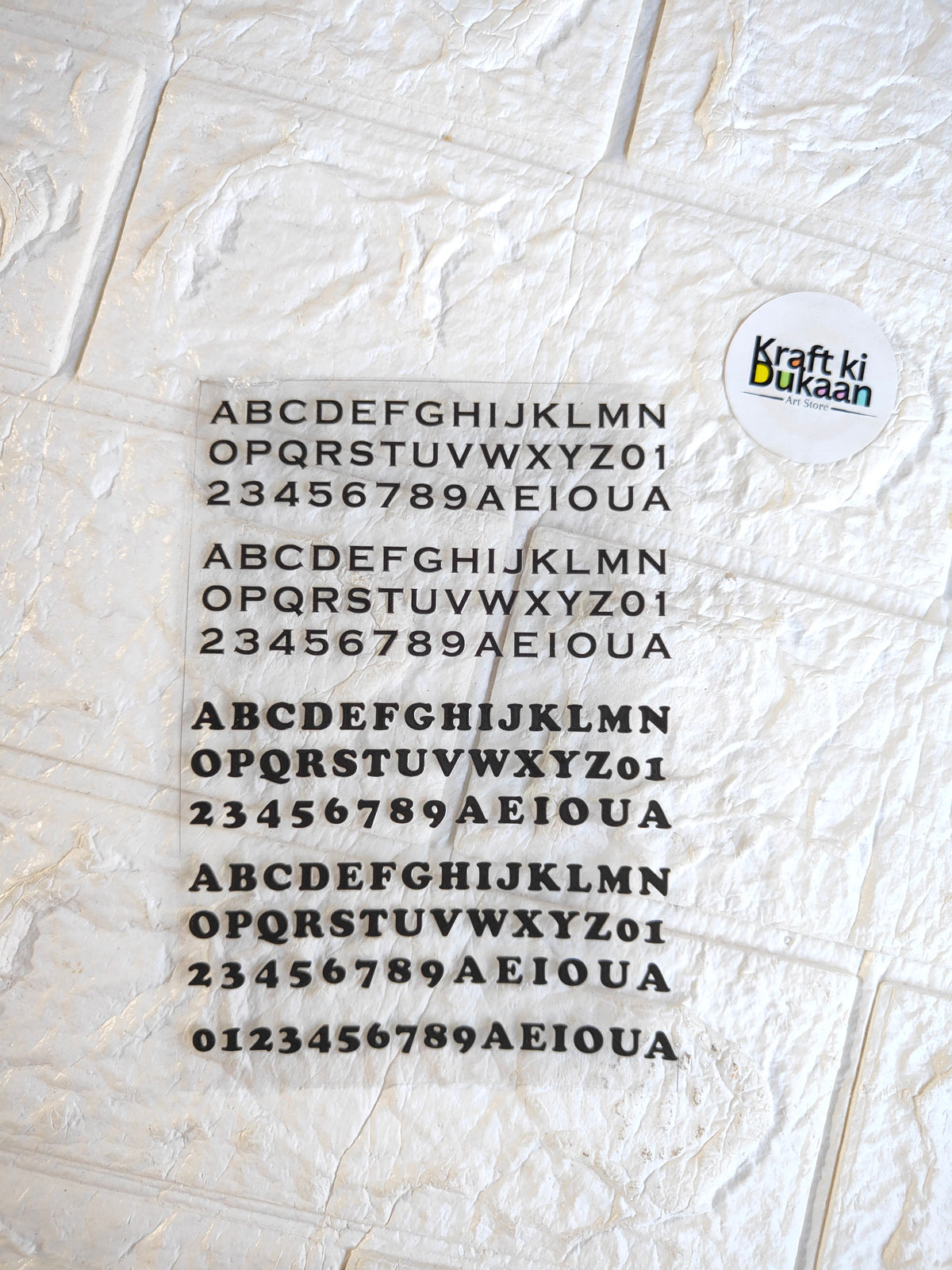 UV DTF peel-off sticker sheet with black alphabet and number grid, Kraft ki Ukai logo