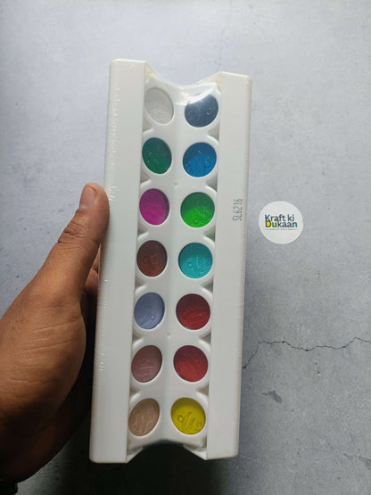 Poster colour paint tray with assorted color wells, held in hand