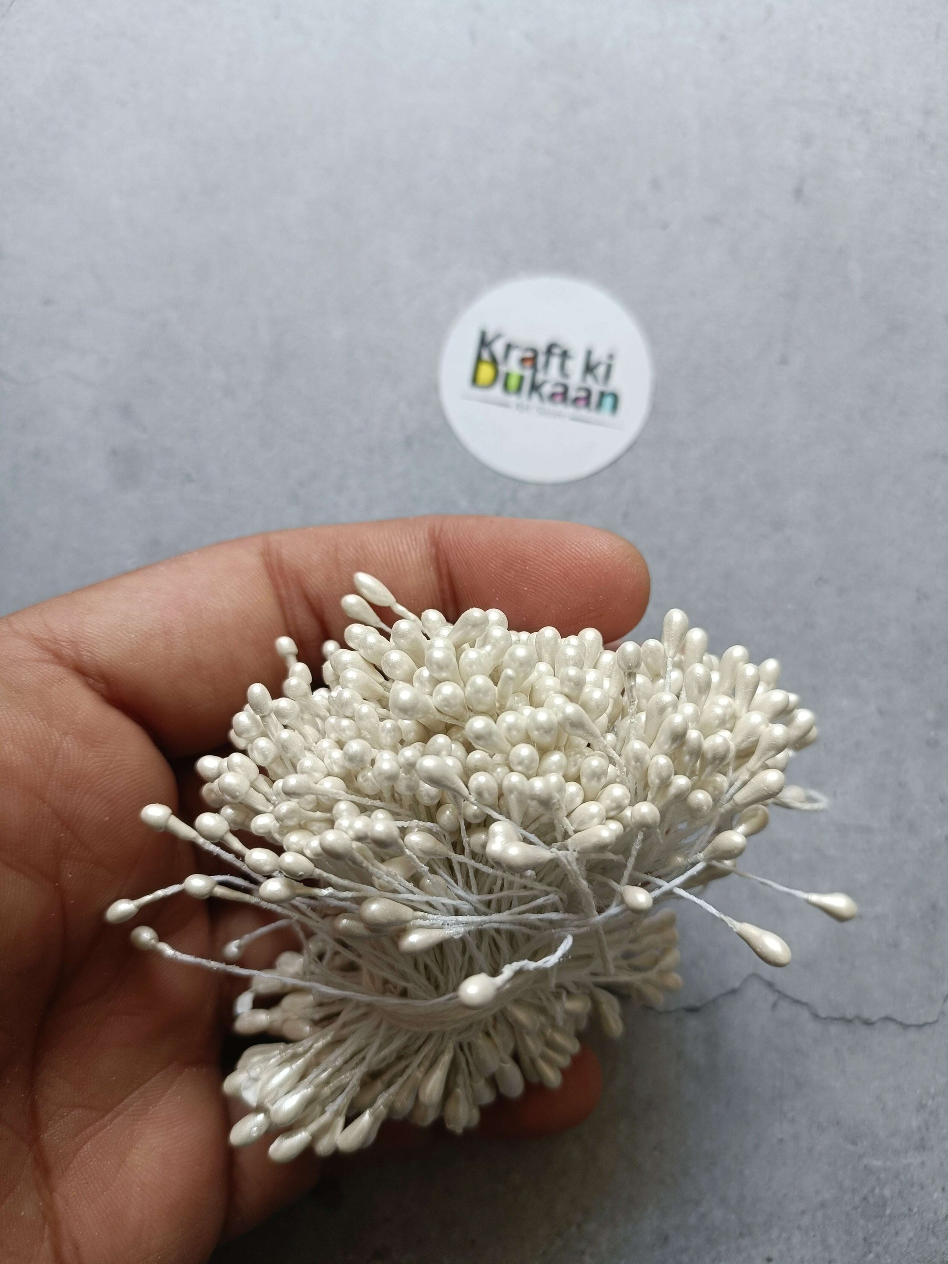 White pollen bunch, held in hand, with pearl-like buds and fine stems