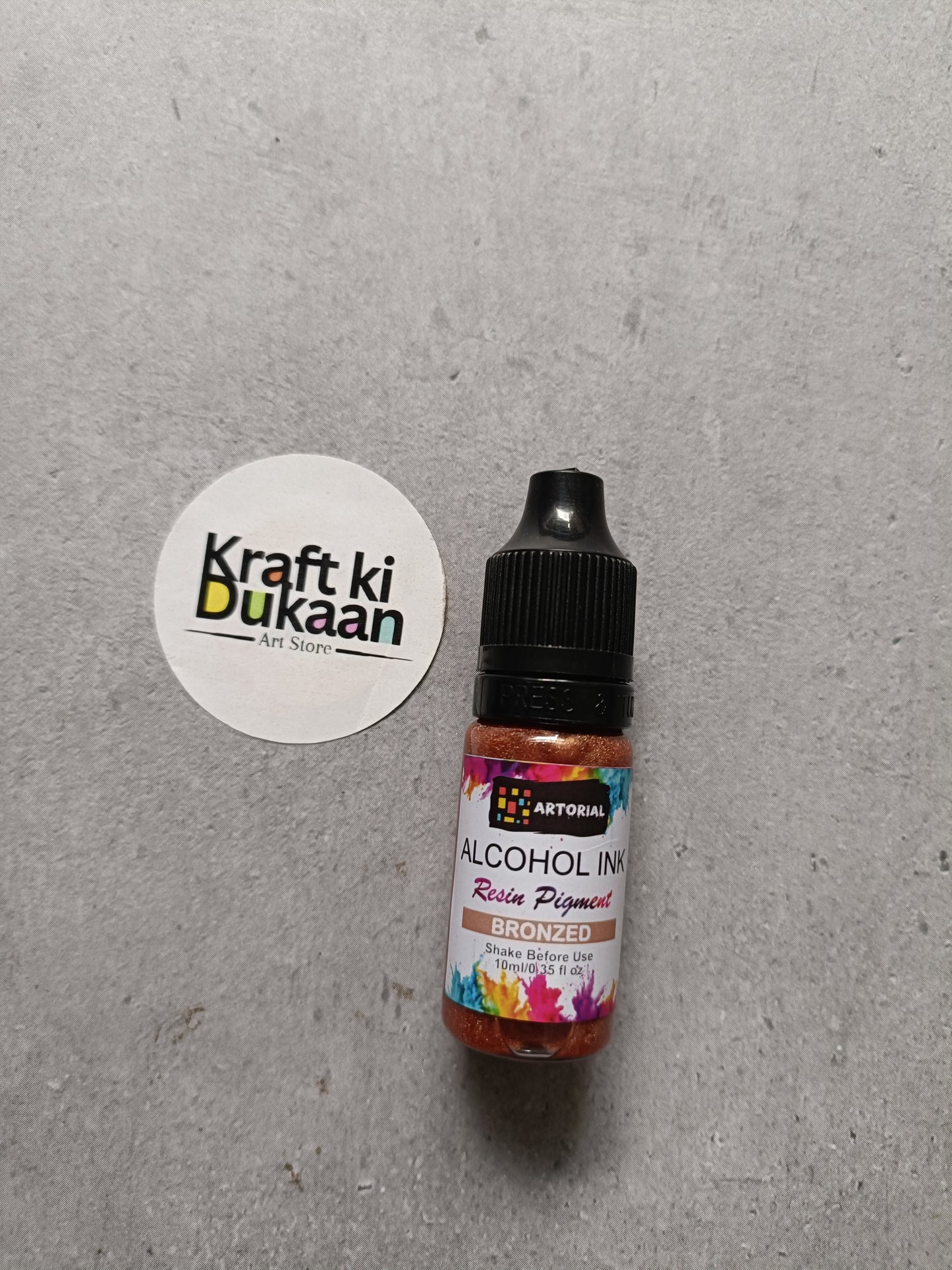 Alcohol ink bottle with black cap, bronzed resin pigment label