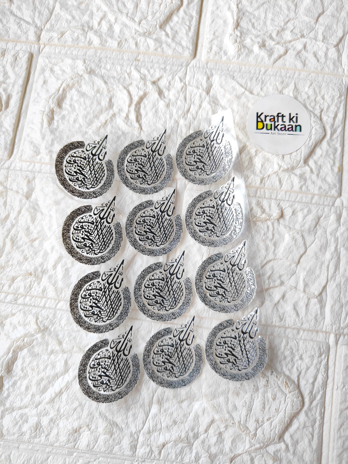 Peel-off sticker sheet with circular gray script designs, multiple stickers