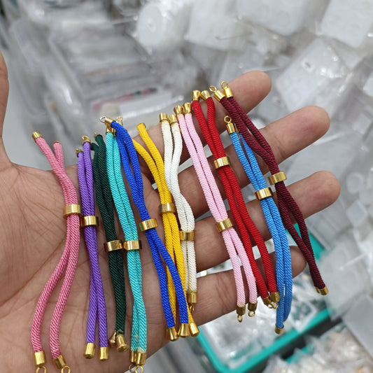 Assorted braided Rakhi thread cords in multiple colors with gold end caps