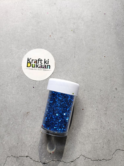 Hexagon glitter jar with royal-blue glitter in a small white-lidded bottle