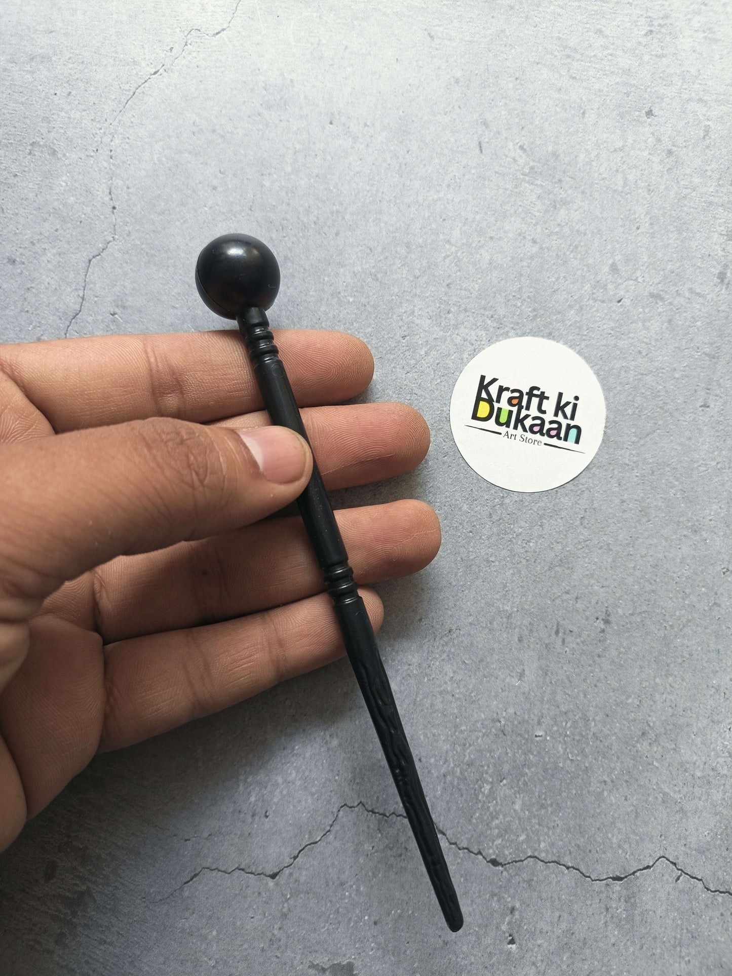 Black clay modelling ball stylus with ribbed grip, close-up