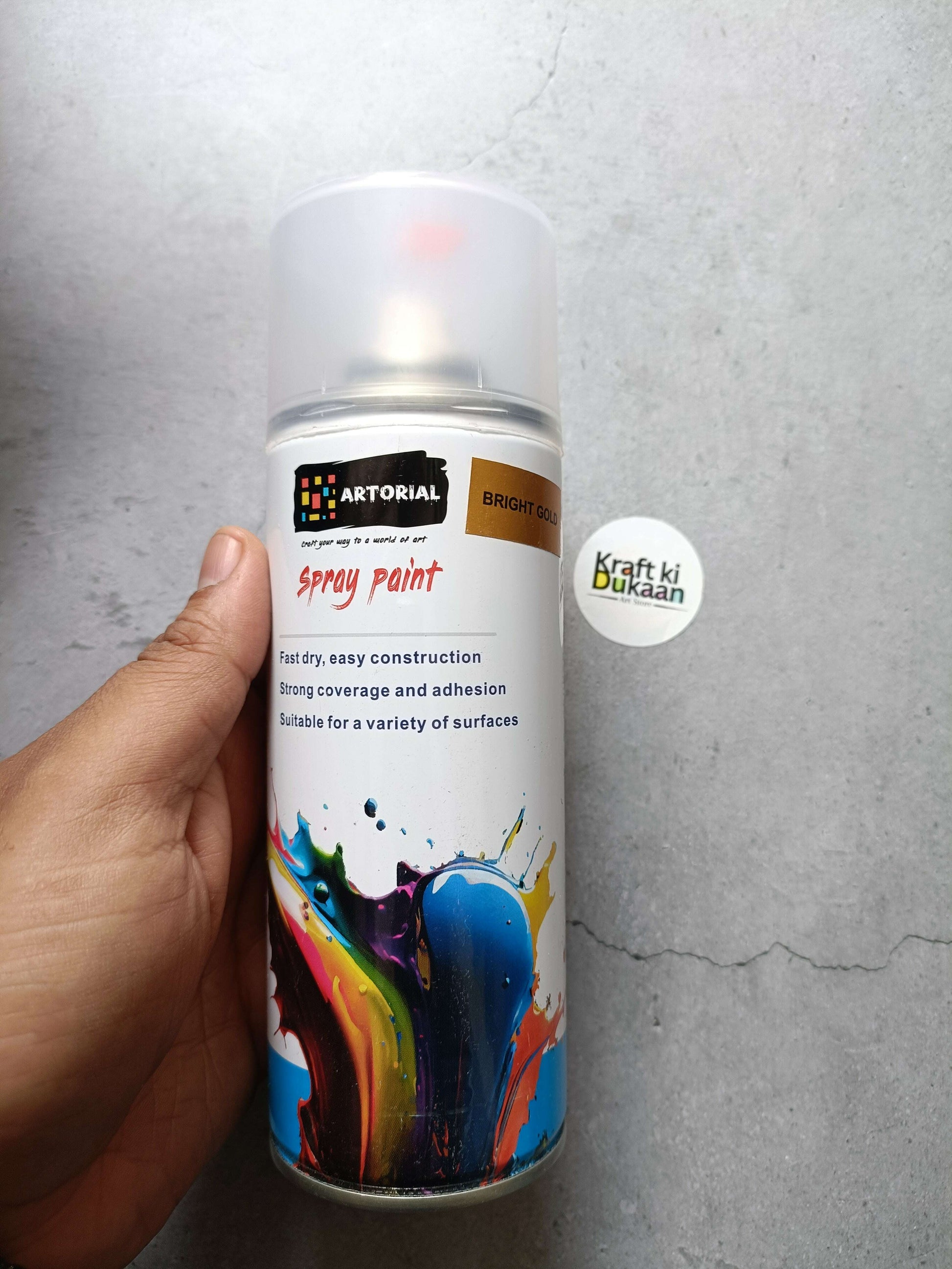 Bright gold spray paint can with colorful splatter label and “Kraft ki Dukaan” sticker