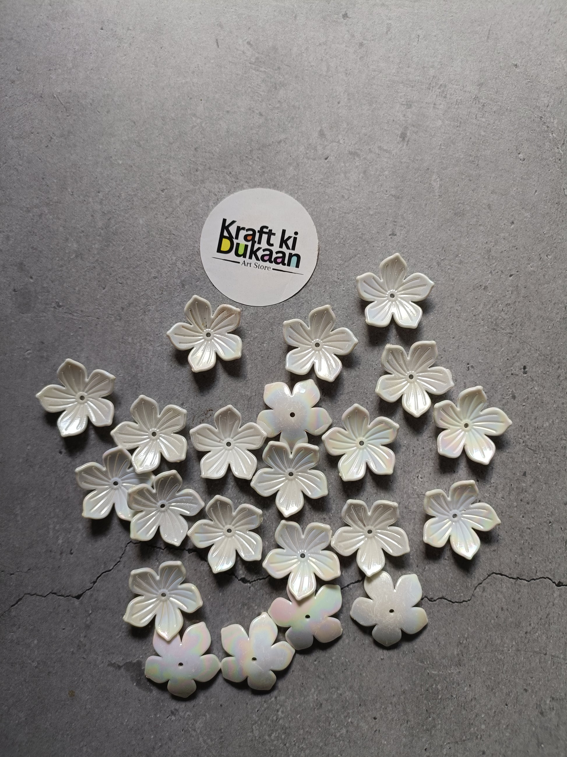 White five-petal flower beads scattered on surface