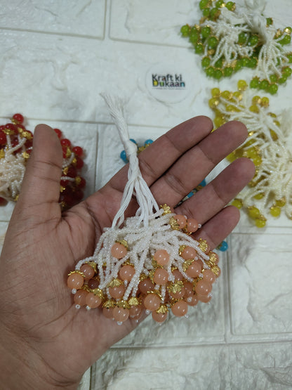 Beaded tassel with white fringe, pink peach beads and gold accents