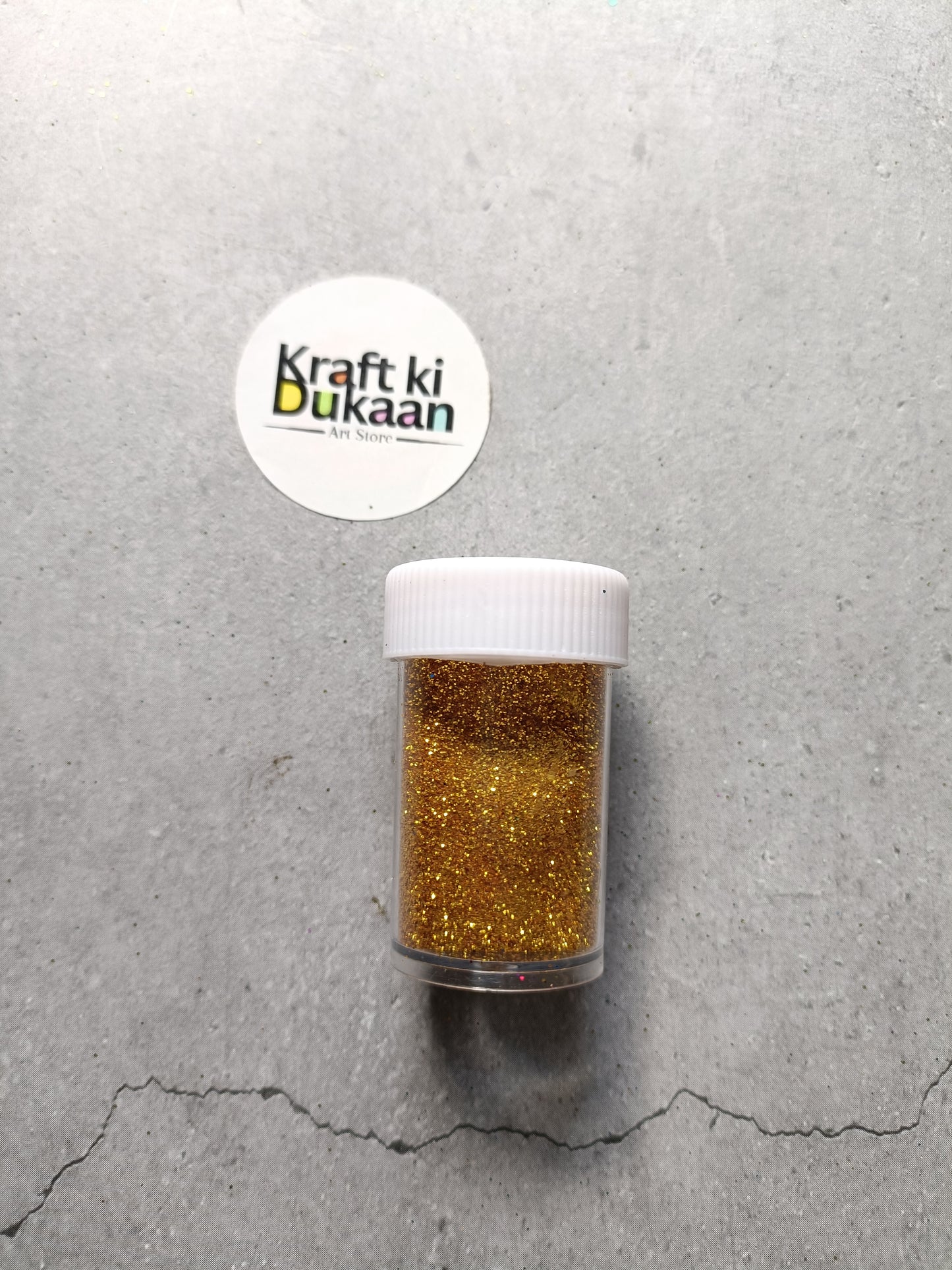 Golden chunky glitter powder jar with white lid.