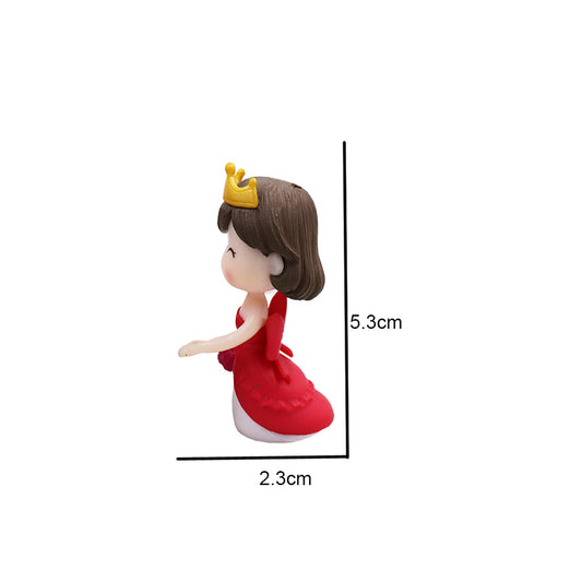 Miniature doll figure in red dress with yellow crown, side view