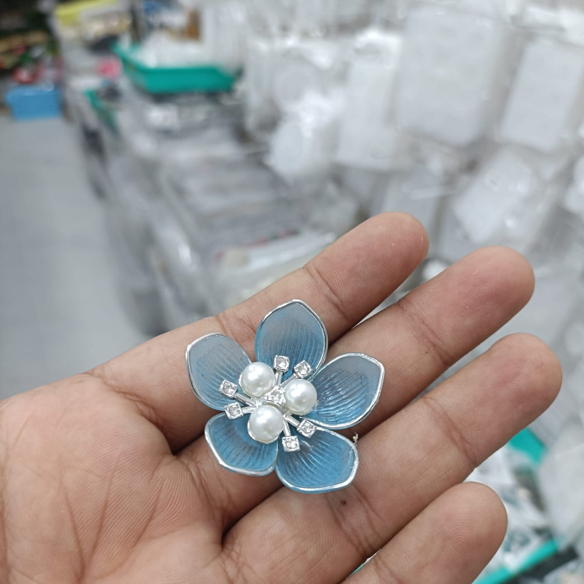 Silver-tone acrylic petal pearl flower with light blue petals, white pearls, and rhinestone details