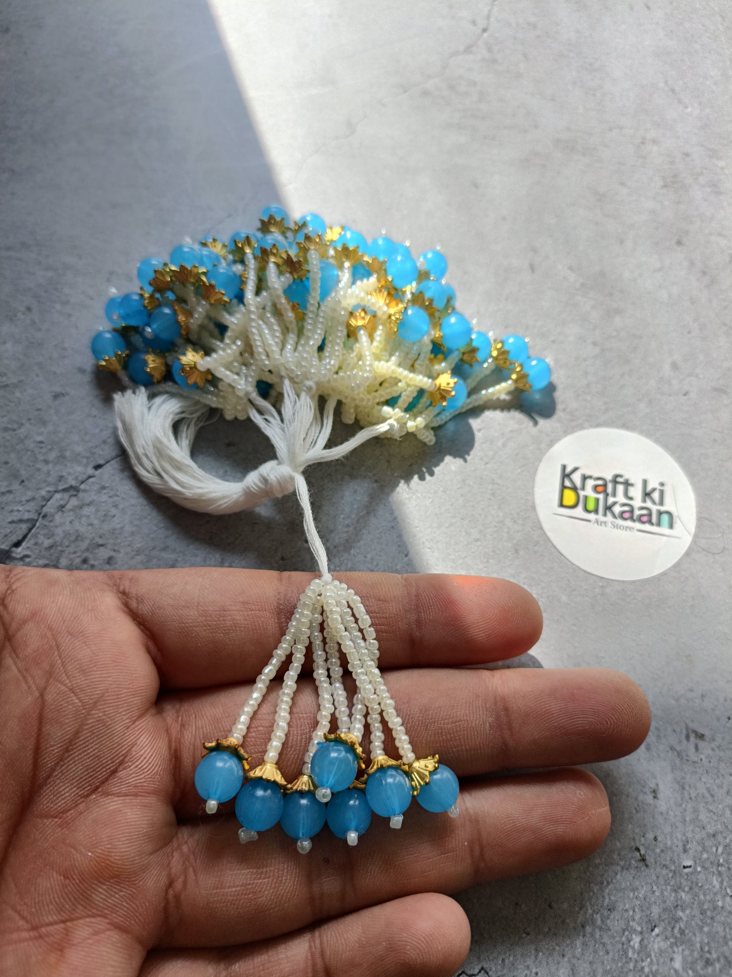 Beaded latkan with white tassel branches and blue bead clusters