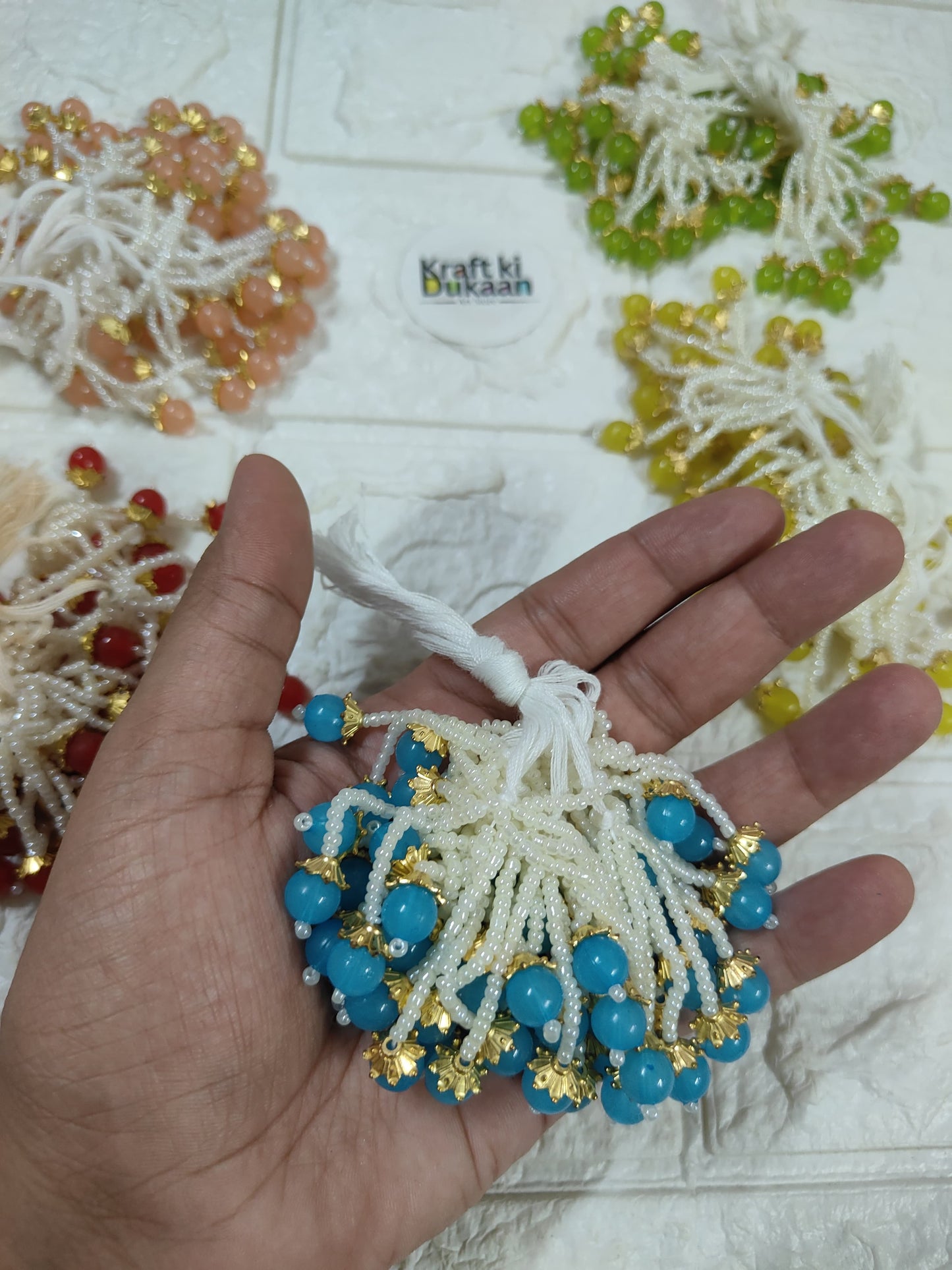 Beaded tassel with white fringe, blue and gold dangling beads
