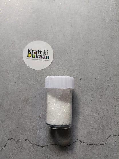 White chunky glitter powder jar with white lid.