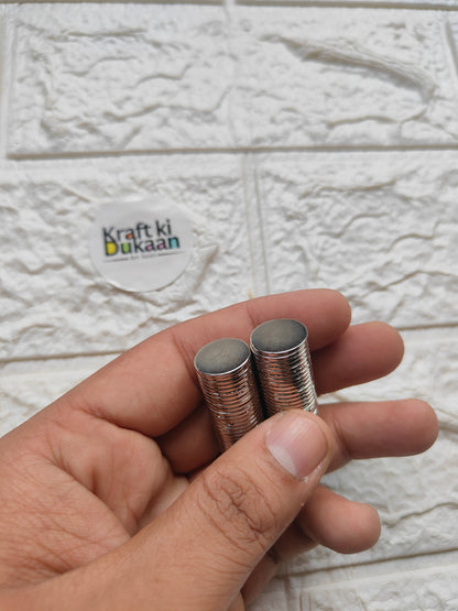 Round steel magnets, 15 x 1.5 mm, small stack held in hand