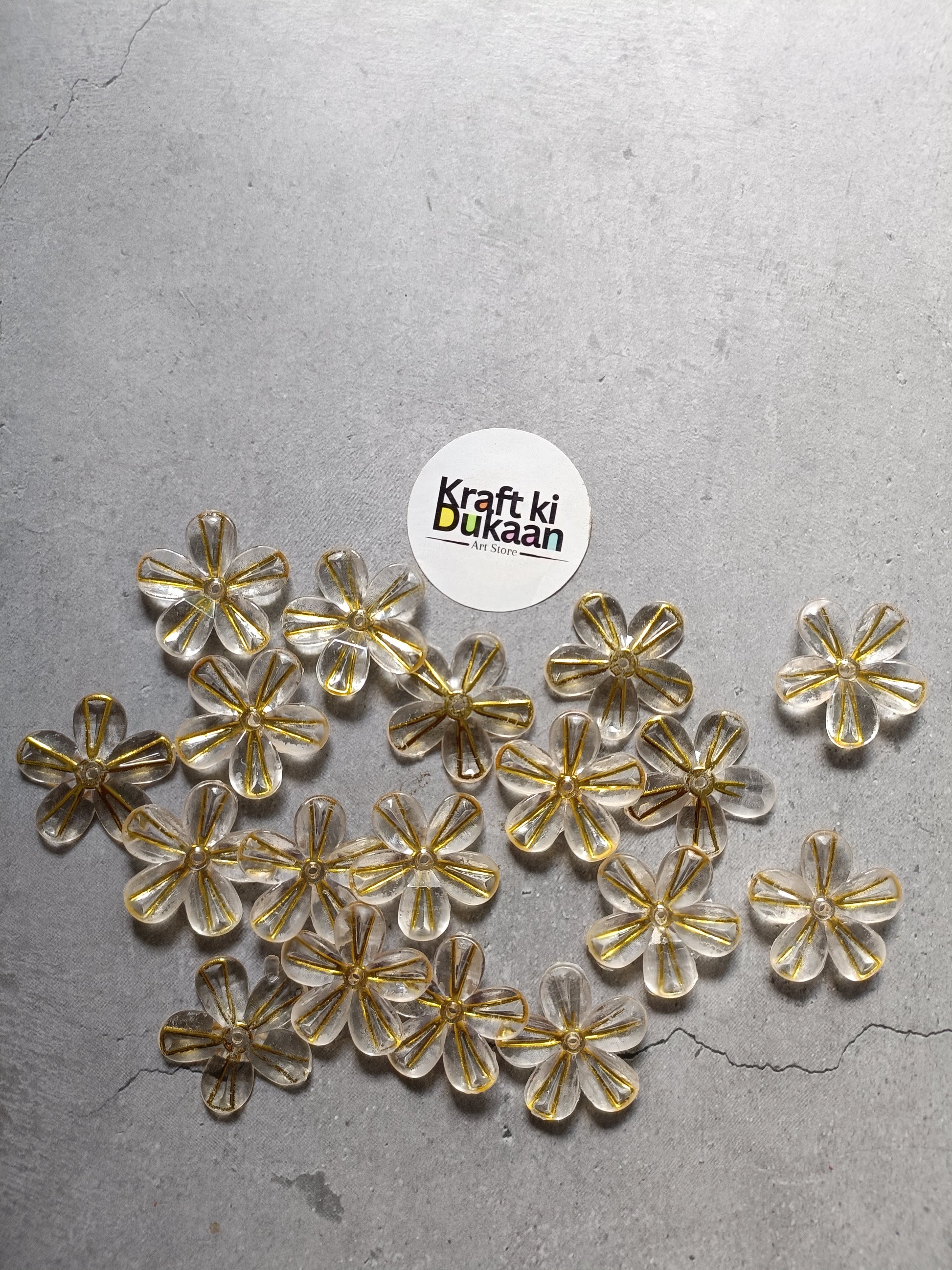 Pack of golden flower bead charms with metallic gold and clear accents laid out