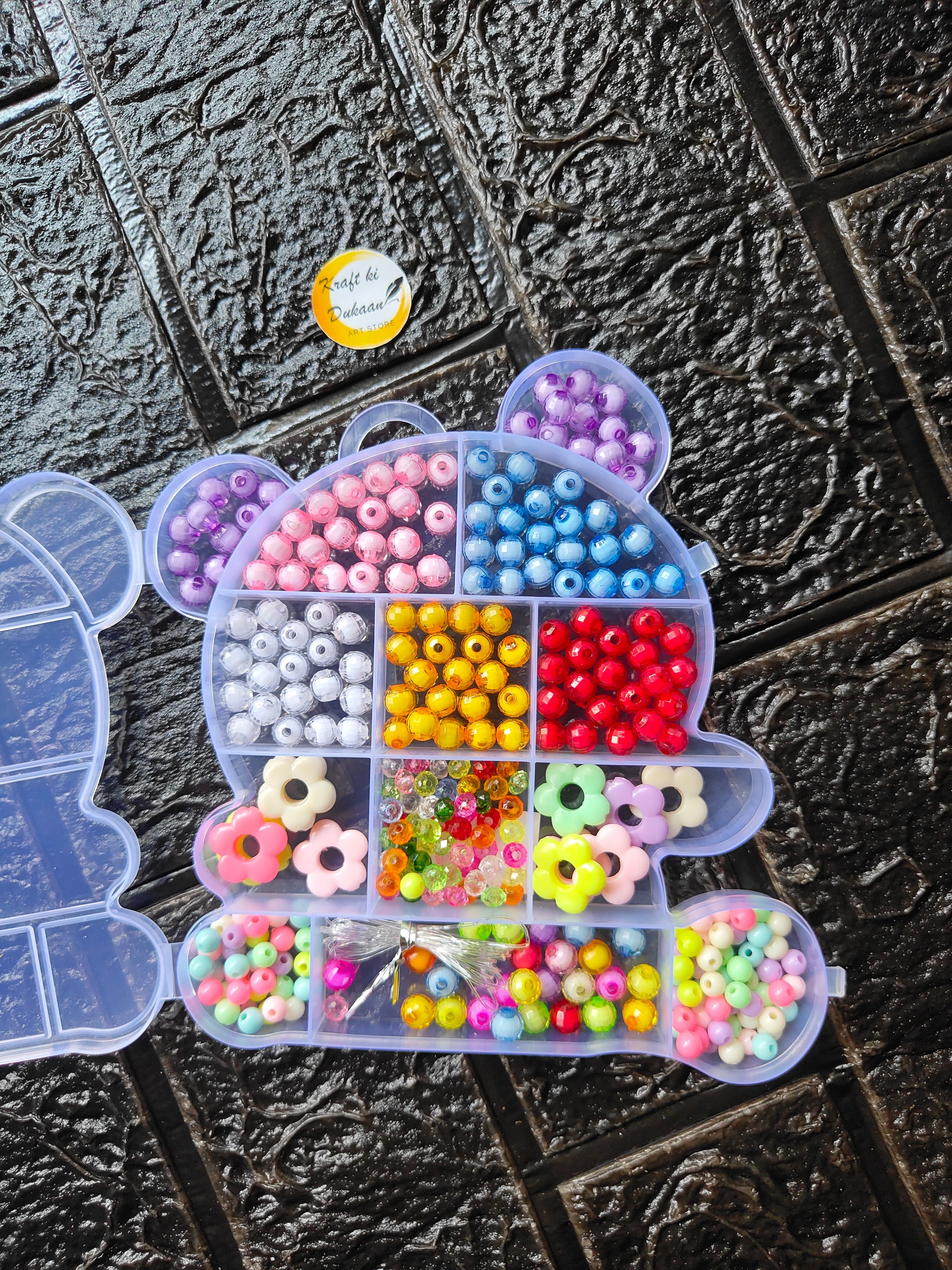Heart-shaped bead organizer with pastel and bright round beads for DIY bracelets