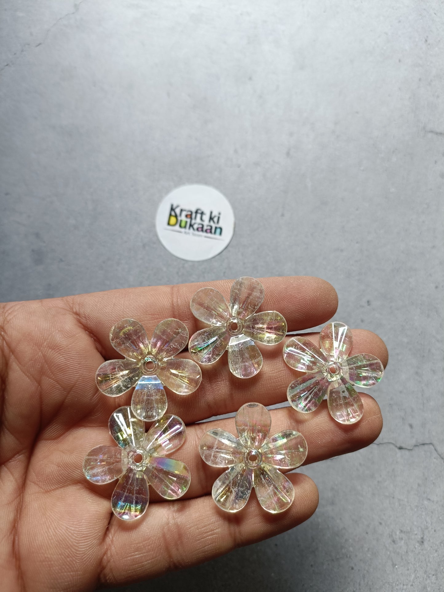 Rainbow flower beads pack, clear iridescent 5-petal beads held in hand