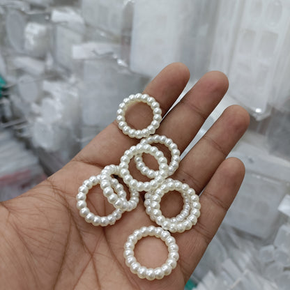 White pearl bead rings, round loop bands shown in hand (pack of 25)