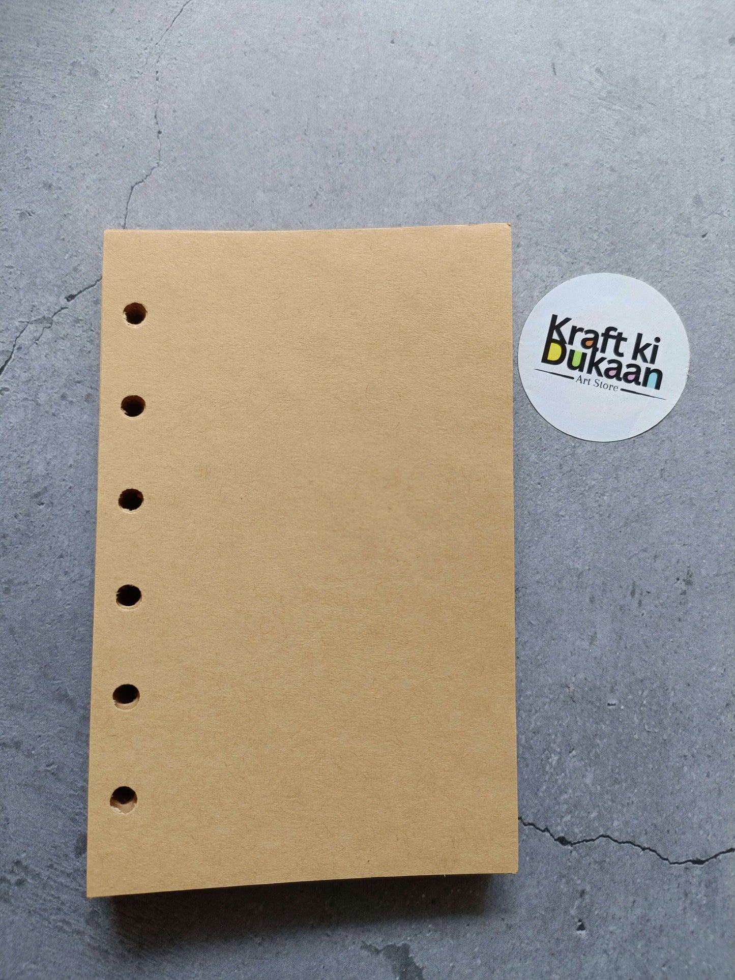 Light brown paper pages with left punched holes, flat view