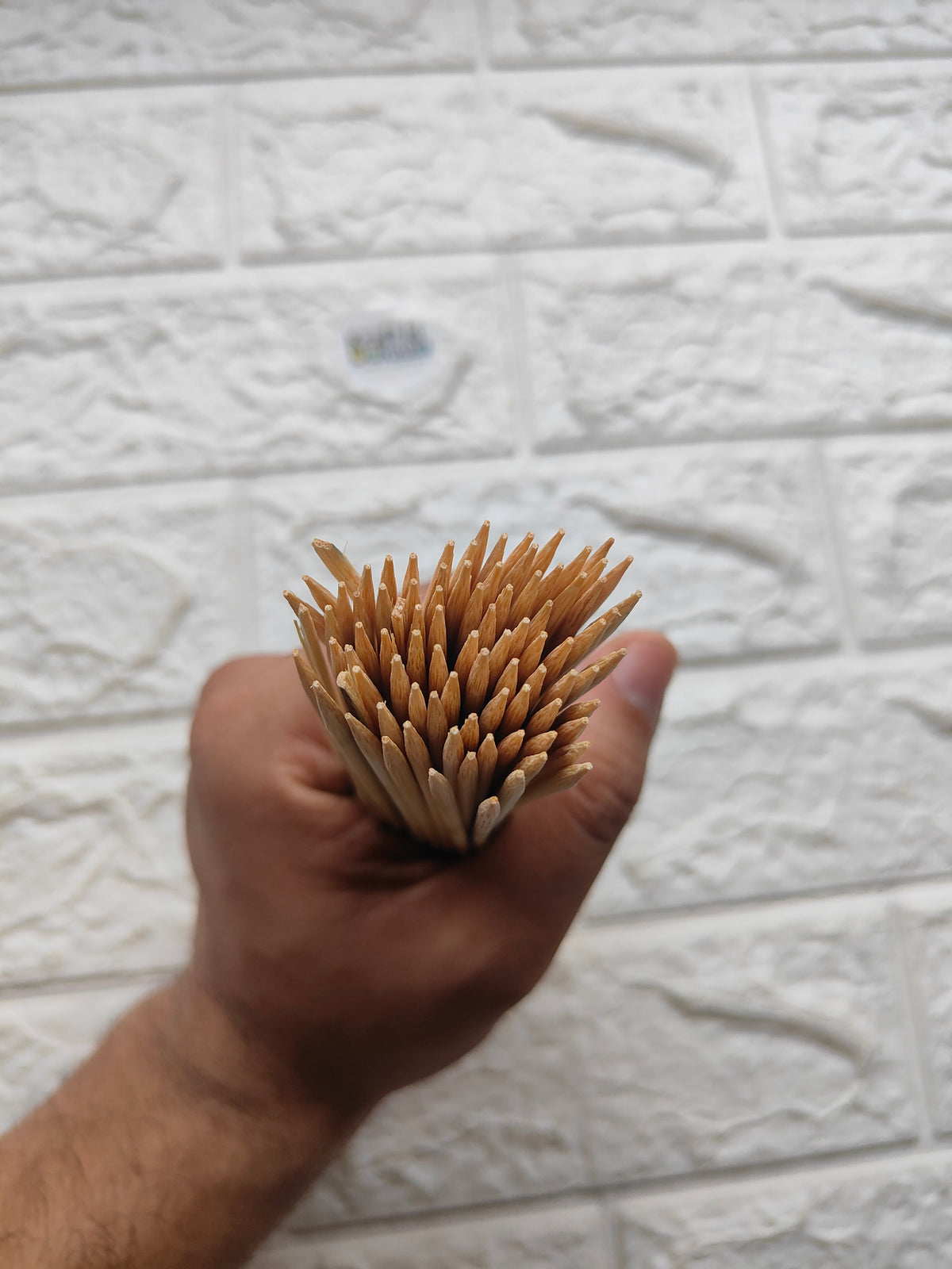 Bundle of wooden bamboo chopsticks held in hand, rounded tips visible