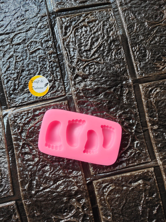 Pink silicone 4-cavity foot mold with four raised foot-shaped impressions
