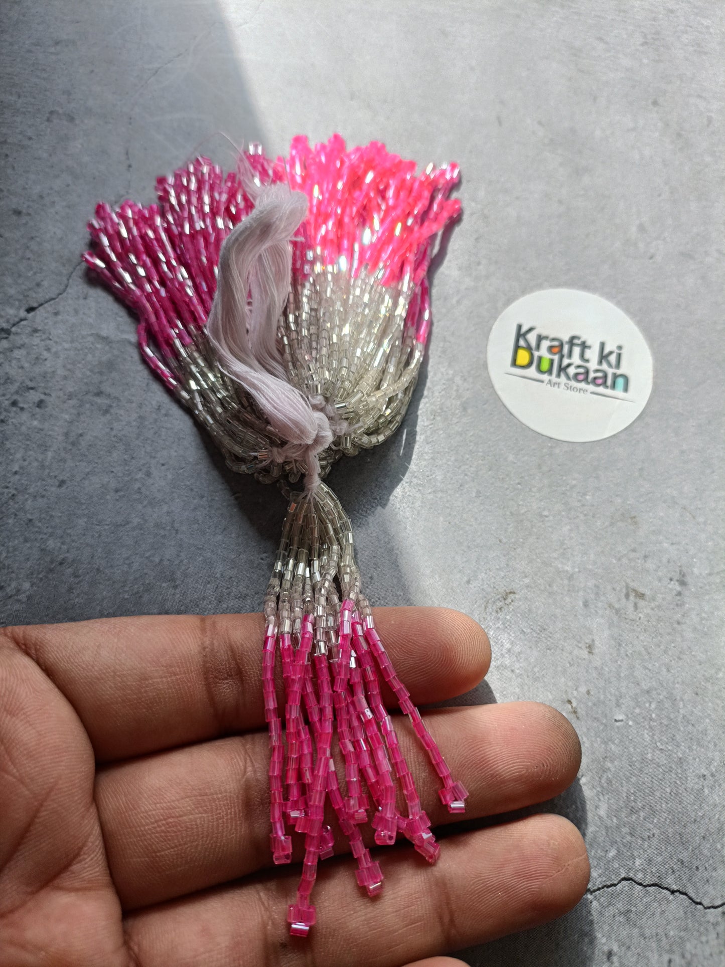 Small beaded tassel latkan with silver top and bright pink fringe.