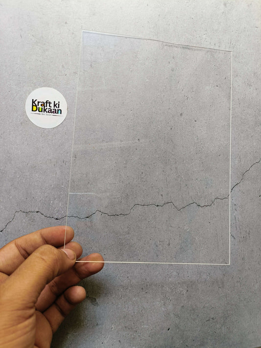A5 clear acrylic sheet held by hand, showing transparent flat panel