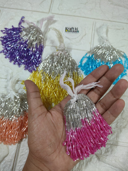 Set of 10 metallic latkan tassels held in hand: orange, yellow, silver, pink and blue