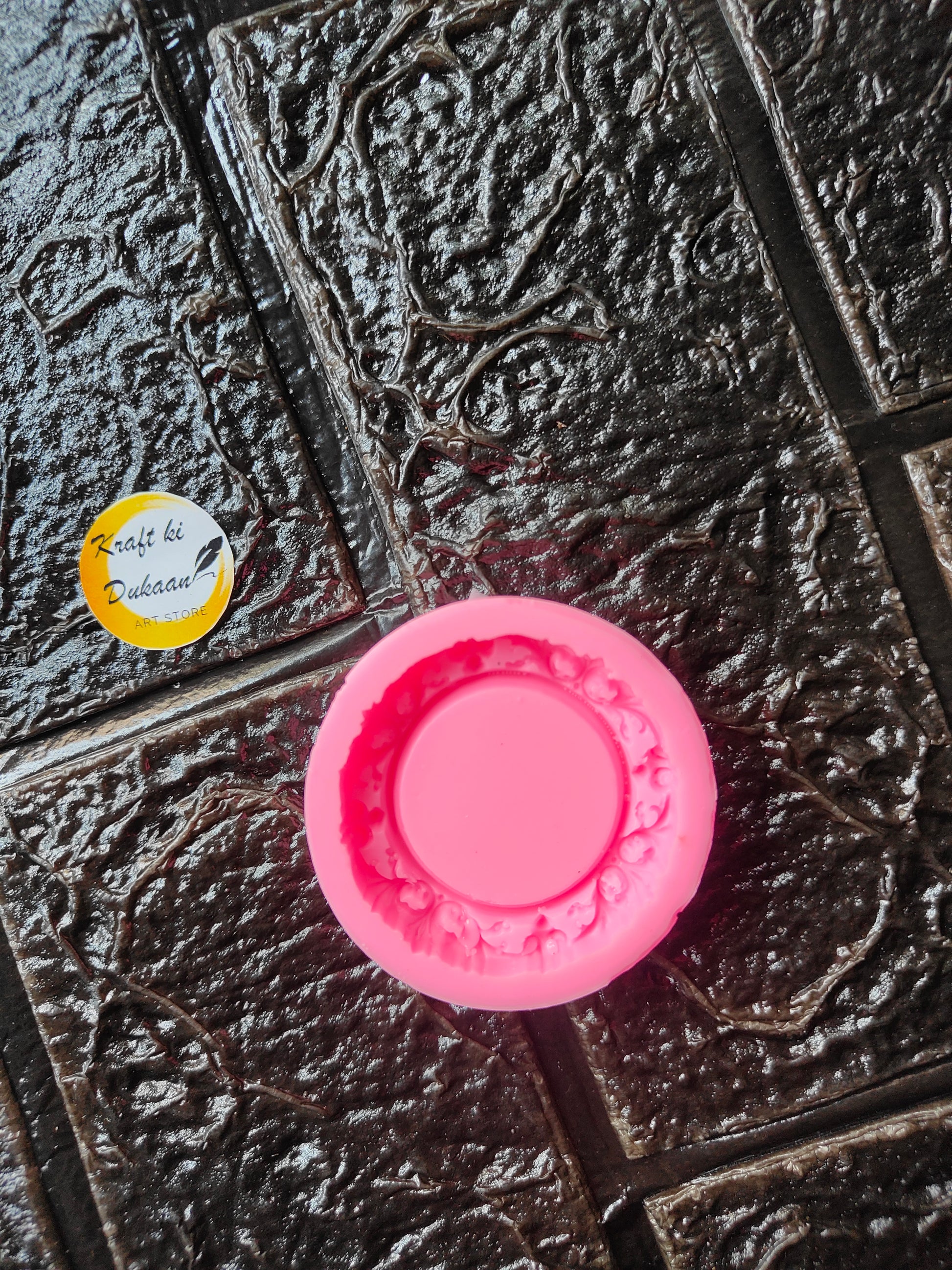 Pink mini round frame mold with embossed floral rim and central circular cavity