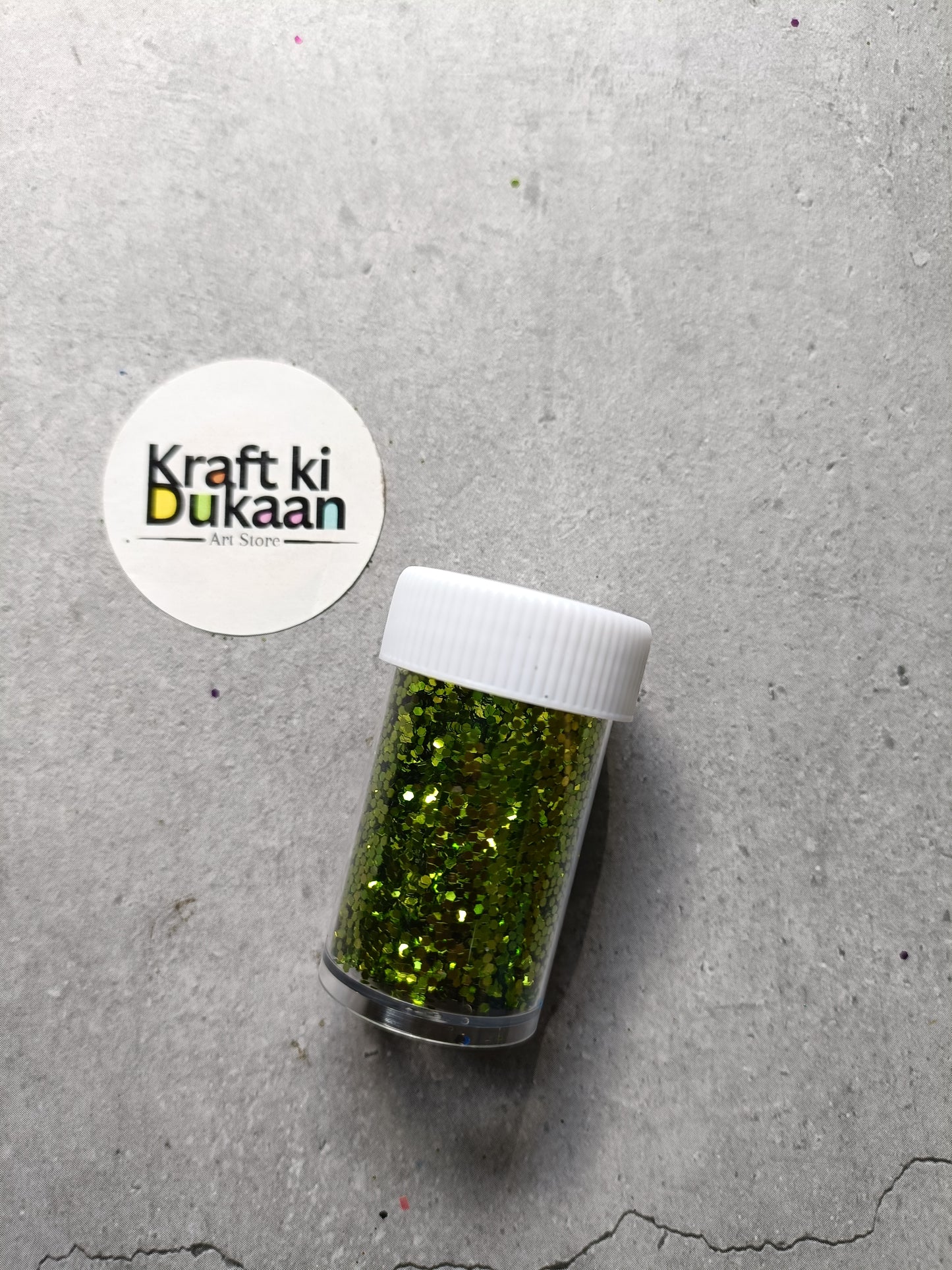 Hexagon glitter jar with yellow-green glitter in a small white-lidded bottle