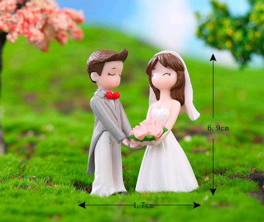Miniature bride and groom figurine set, 6.9 cm tall, standing with bouquet and heart.