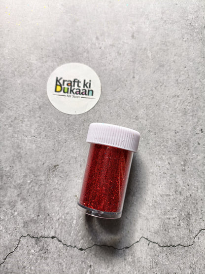 Red chunky glitter powder in clear shaker bottle with white lid