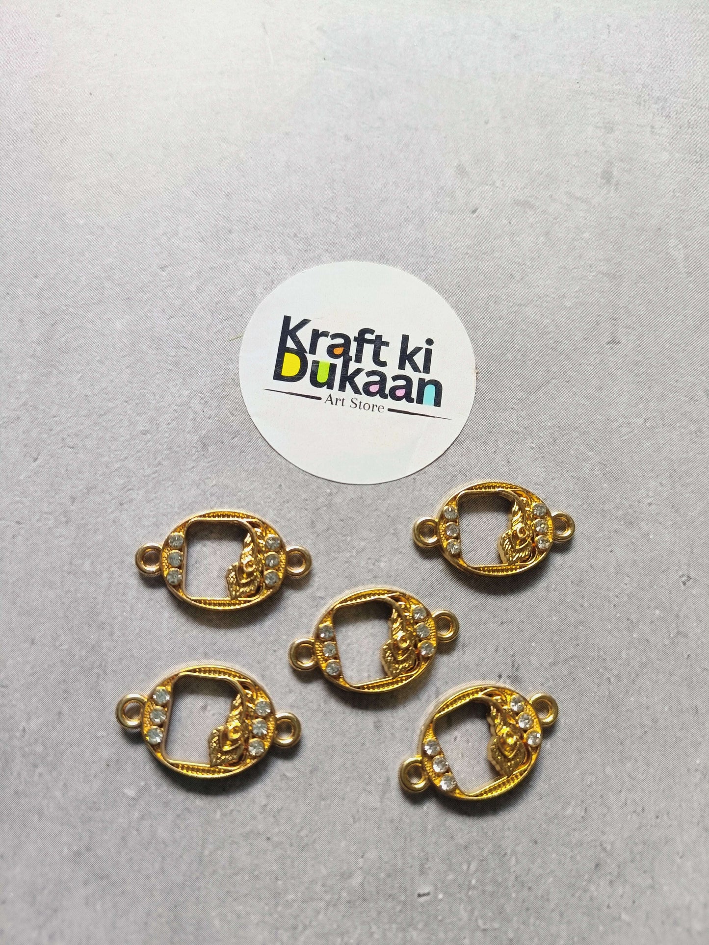 Five gold-tone oval rakhi bracelet bezels with rhinestones and side loops