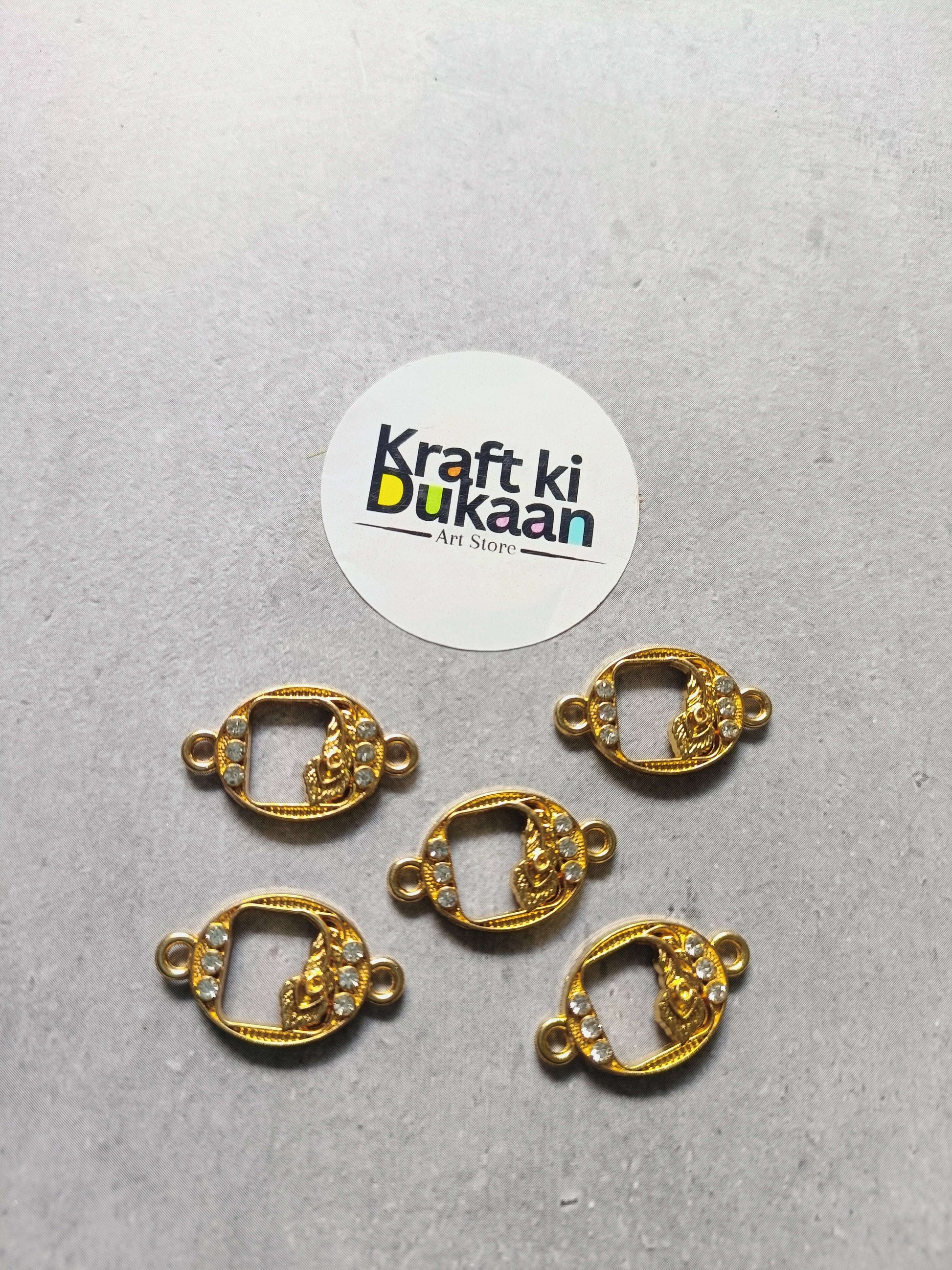Five gold-tone oval rakhi bracelet bezels with rhinestones and side loops