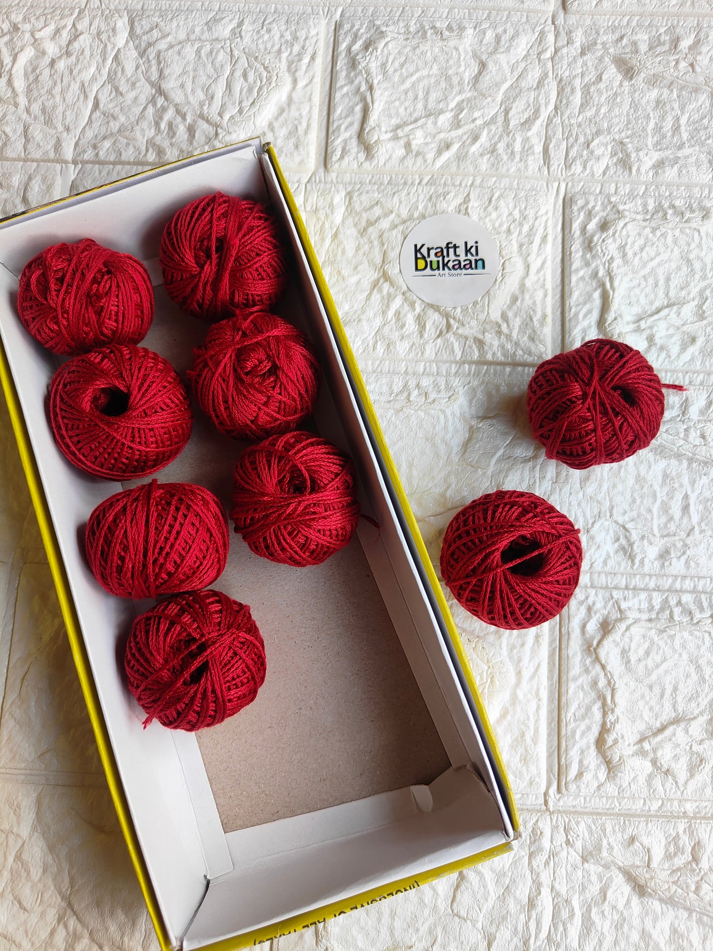 Rakhi thread roll set with red yarn balls in an open cardboard box