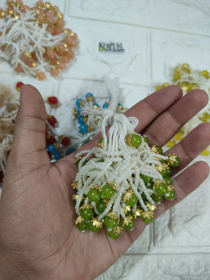 Beaded tassel with white fringe, green beads and gold accents