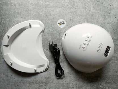 White UV LED nail lamp beside white curing base and black power cable