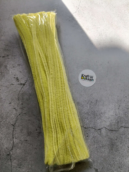 Pale yellow pipe cleaners bundle in clear packaging, fuzzy chenille texture.