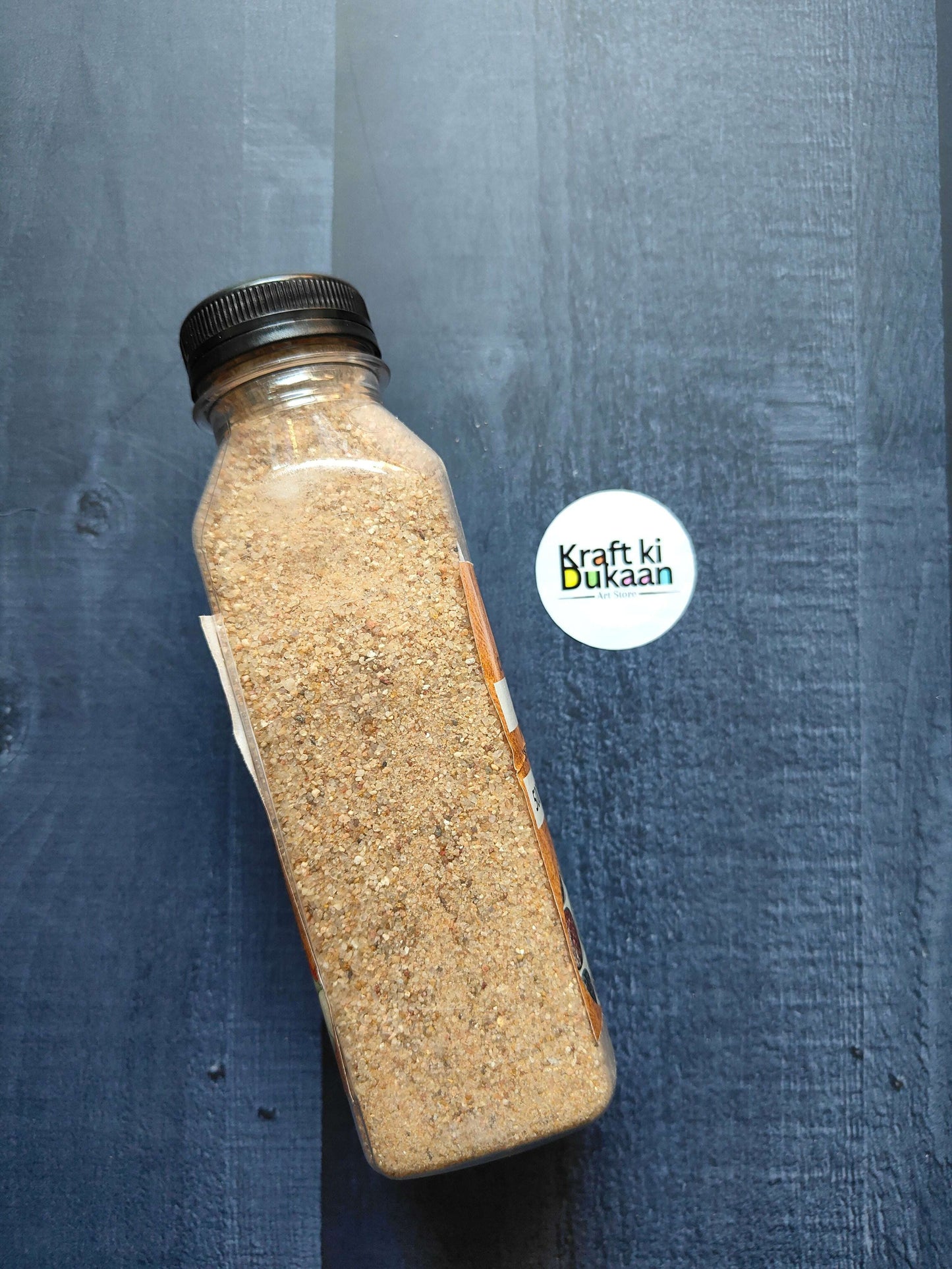 Natural sand in clear bottle with dark screw cap, 500g