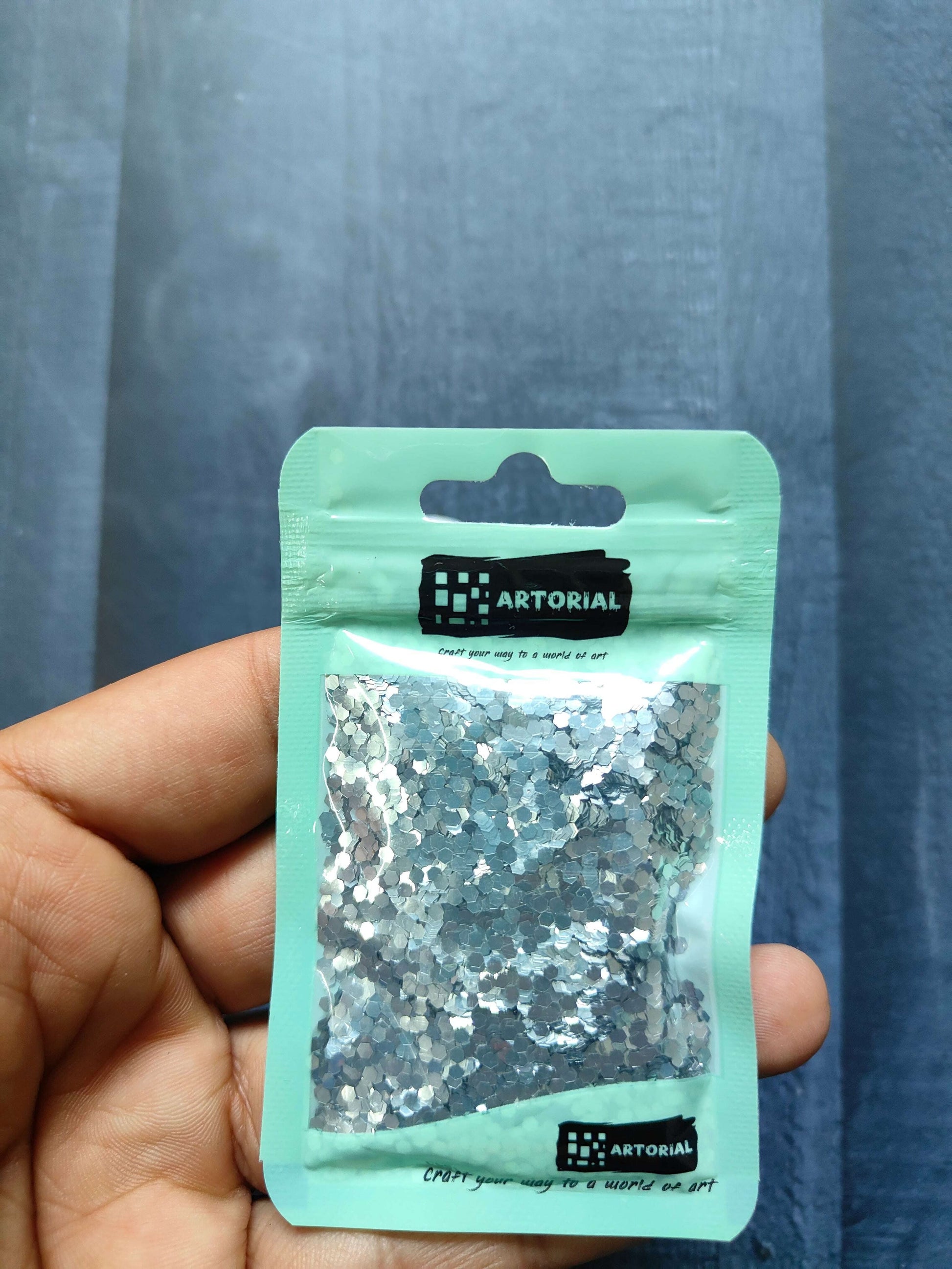 Glitter Shapes Sequins pack, silver hex sequins in mint-green pouch (close-up)